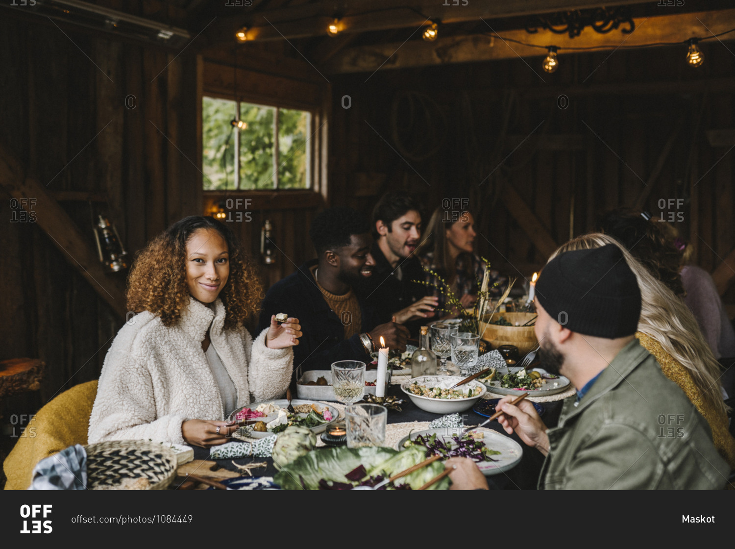 Portrait of smiling woman enjoying with male and female friends during social gathering