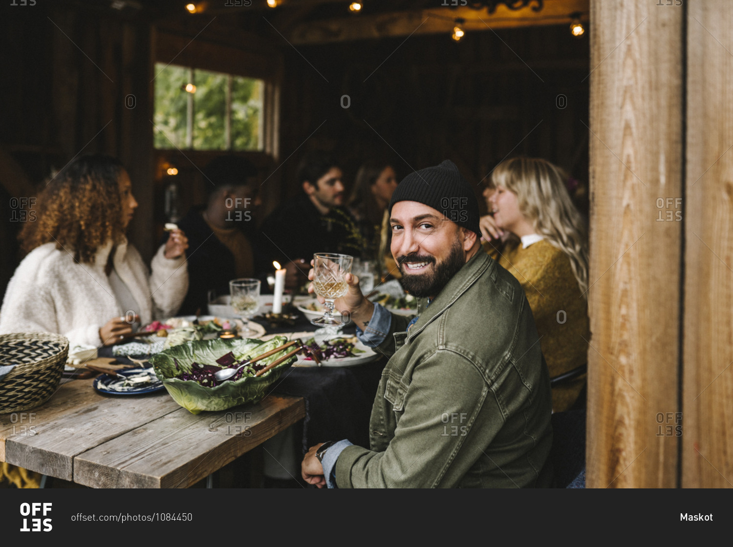 Portrait of smiling man enjoying with male and female friends during social gathering