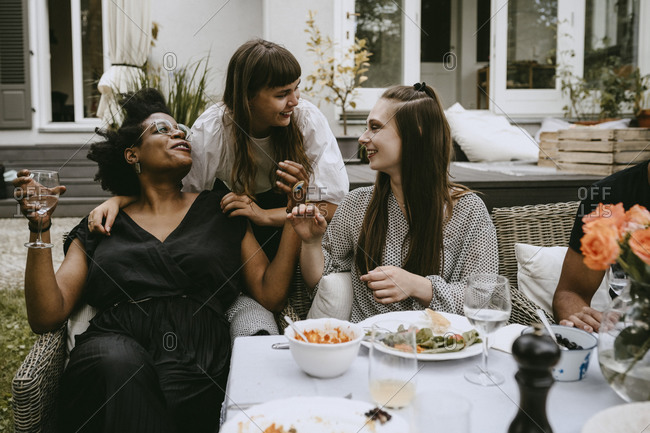 Smiling female friends talking while enjoying during social gathering