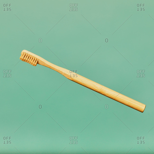 Toothbrush made of bamboo on blue background in studio showing concept of natural eco friendly products