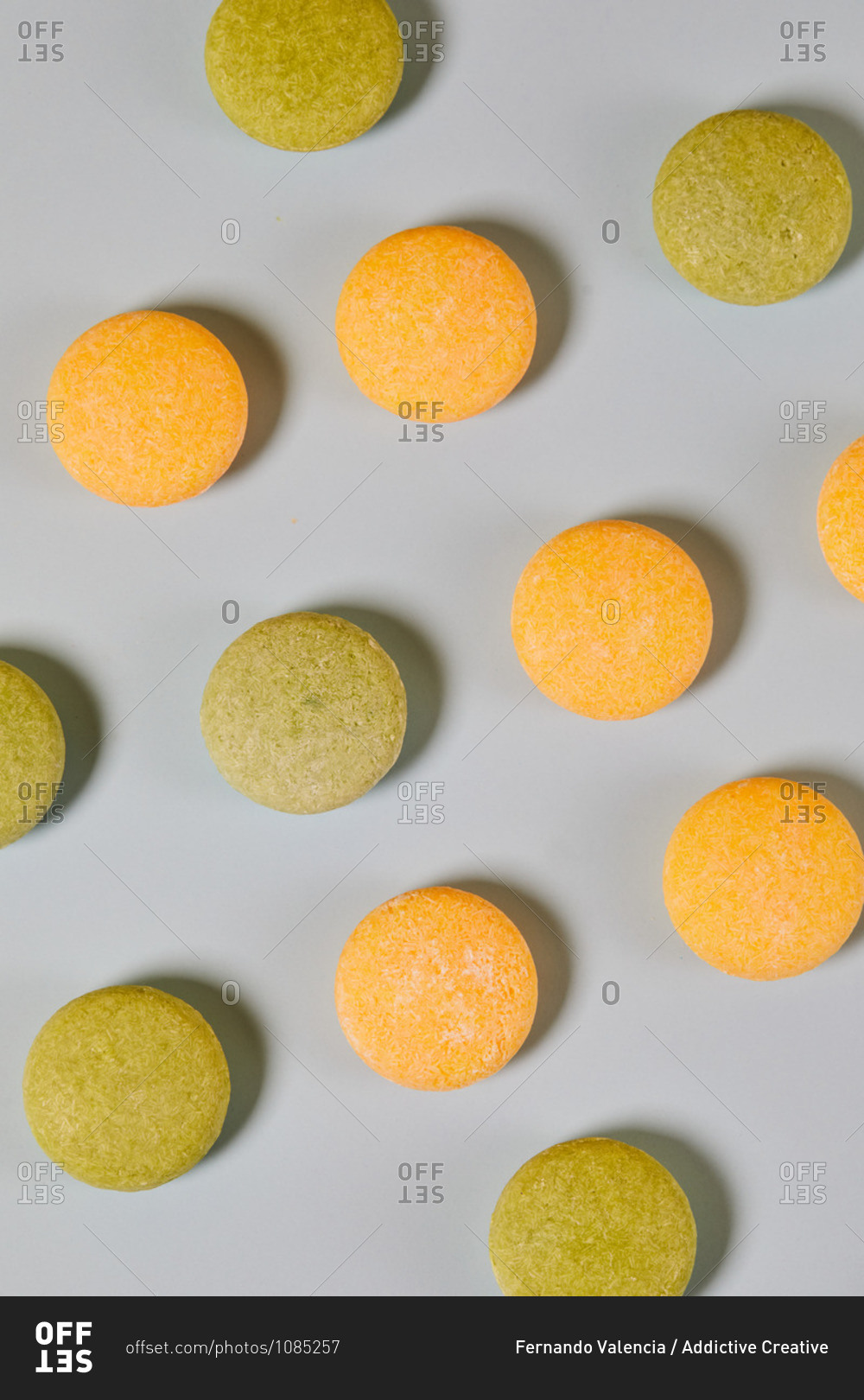 From above of natural round shaped soap arranged on two colored background in studio