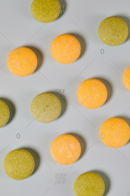 From above of natural round shaped soap arranged on two colored background in studio