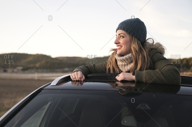 Photo of a Stylish Man Sitting on a Hood of a Black Car · Free Stock Photo
