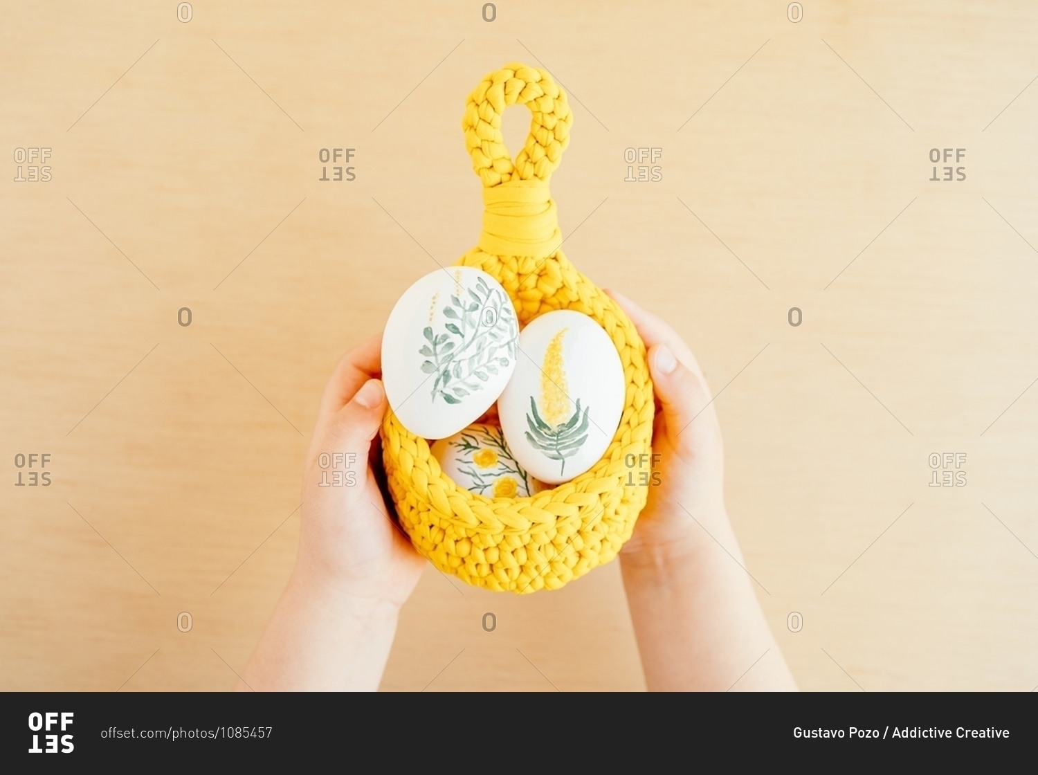 Unrecognizable crop kid with basket of Easter eggs painted with flowers on white isolated background