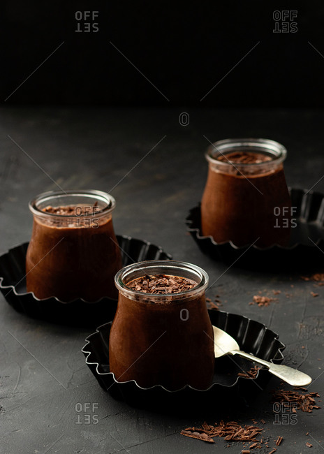 From above tasty chocolate mousse in glass jar arranged on table with chocolate powder dust