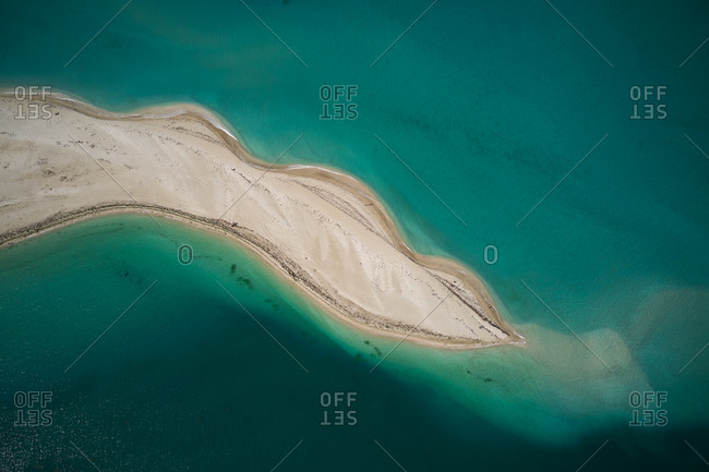 Picturesque drone view of small uninhabited island with sandy coastline and lakes surrounded by turquoise sea water in sunny weather