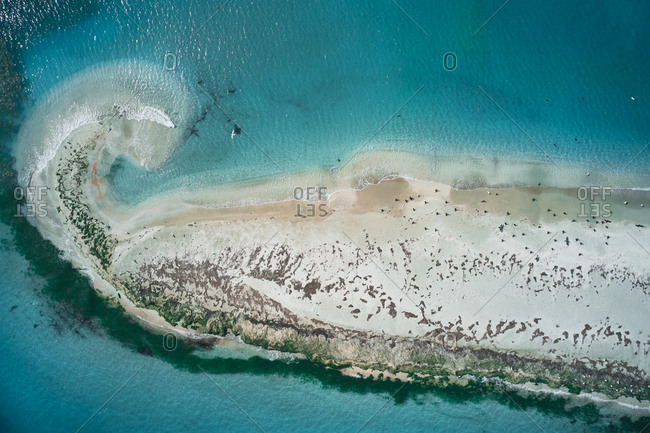 Picturesque drone view of small uninhabited island with sandy coastline and lakes surrounded by turquoise sea water in sunny weather