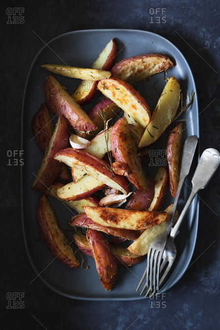 Roasted potato wedges on a serving dish.