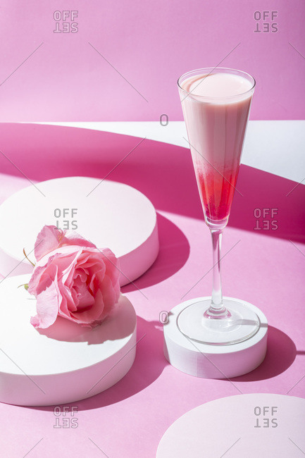 Pink cocktail on a pink background. Minimalistic set design.
