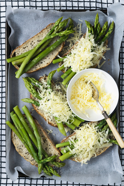 Asparagus spears and grated cheese on wholegrain sourdough bread.