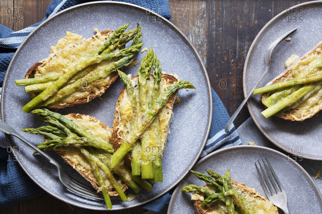 Servings of grilled cheese and asparagus on sourdough bread.