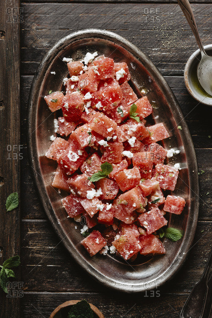 Watermelon salad with feta and mint on a wooden backdrop