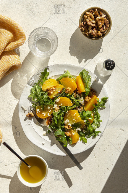 Golden beet salad with arugula, feta cheese and walnuts in a bowl