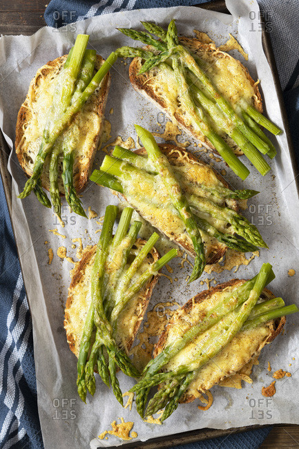 A tray of grilled cheese and asparagus on slices of sourdough bread.