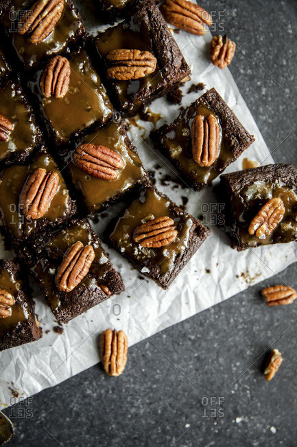Turtle Brownies with salted caramel and pecan topping in a flatlay close up.