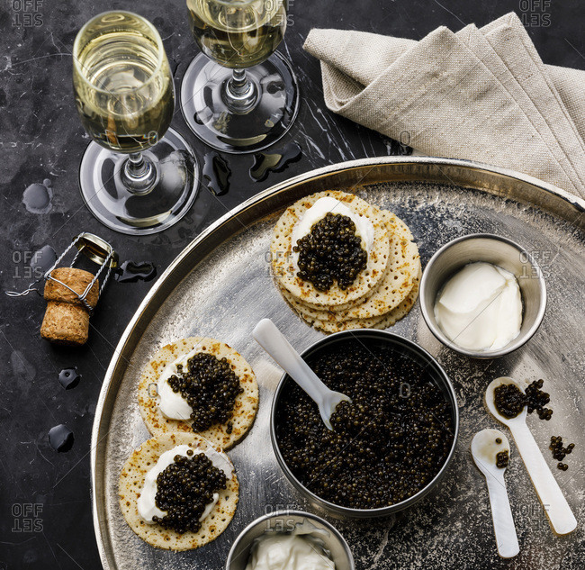 Black Caviar, Mini Pancakes and Sour Cream Holiday Party Appetizer on dark marble background