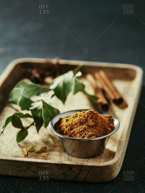 Indian or Pakistani masala powder and spices on wooden tray.