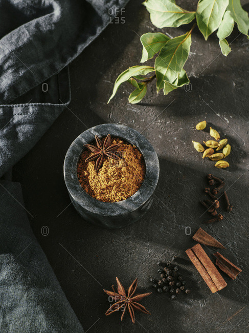 Indian or Pakistani masala powder and spices on wooden tray.