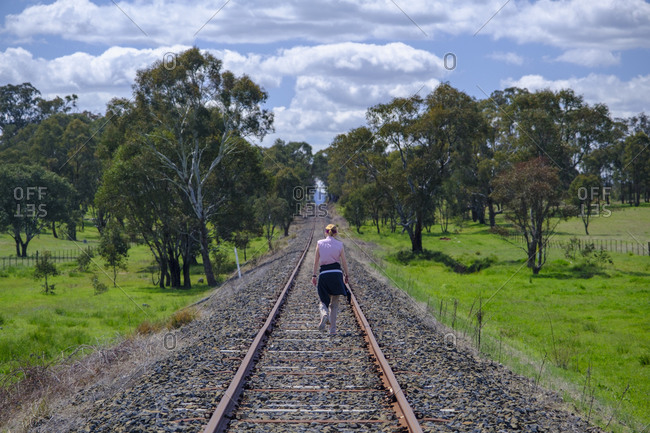 Australia, New South Whales, Woman hiking along railroad track