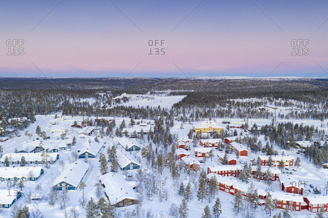 Aerial view of snow capped forest and Saariselka winter tourist resort at sunrise, Inari, Lapland, Finland, Europe