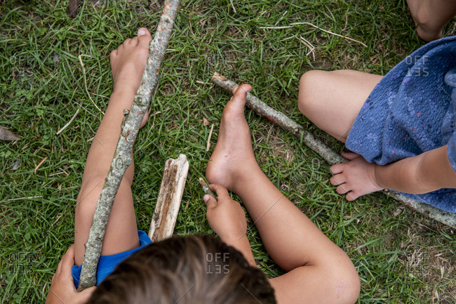 Cropped view of children with sticks