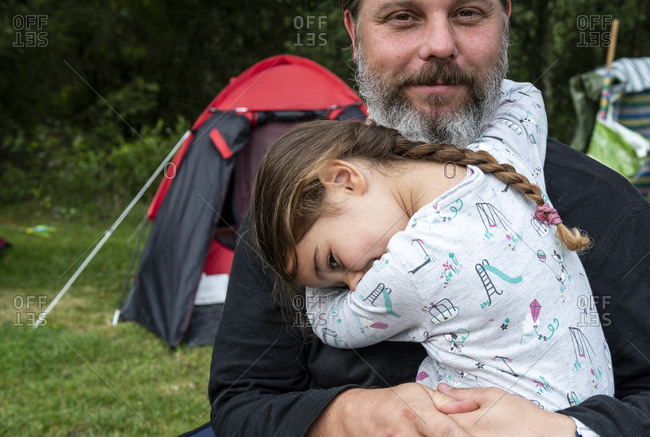Father hugging daughter at camp site