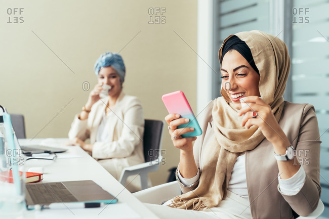 Businesswoman in office, using phone