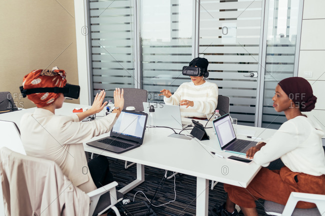 Colleagues using virtual reality headsets in office