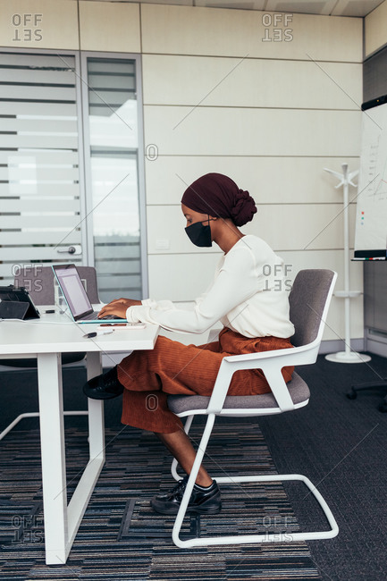 Businesswoman wearing face mask, working in office
