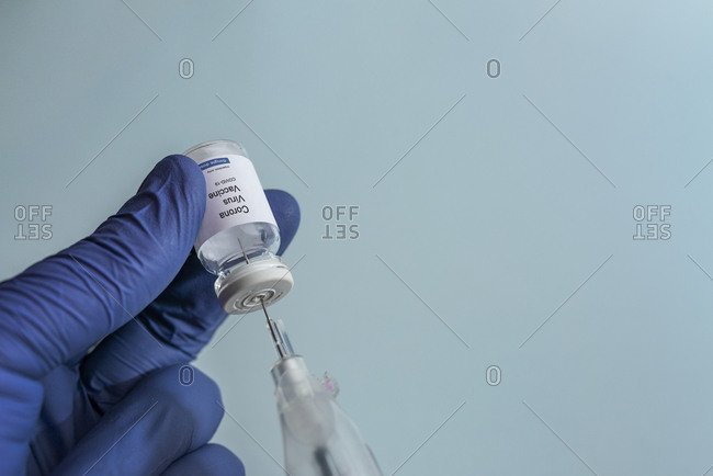 Hand holding syringe and vial with Coronavirus Covid-19 vaccine