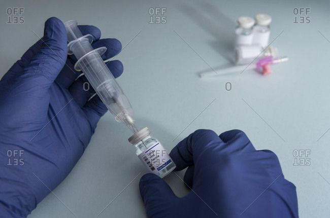 Hands holding syringe and vial with Coronavirus Covid-19 vaccine
