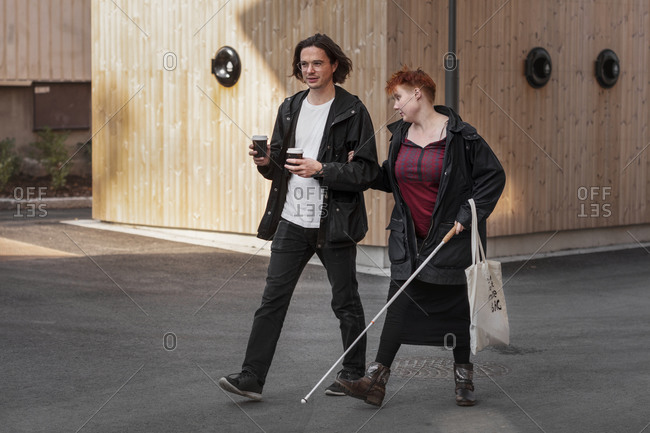 Visually impaired woman walking with male friend