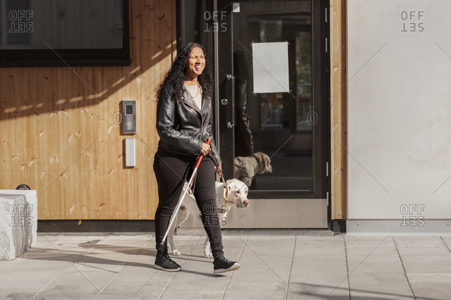 Visually impaired woman walking with guide dog