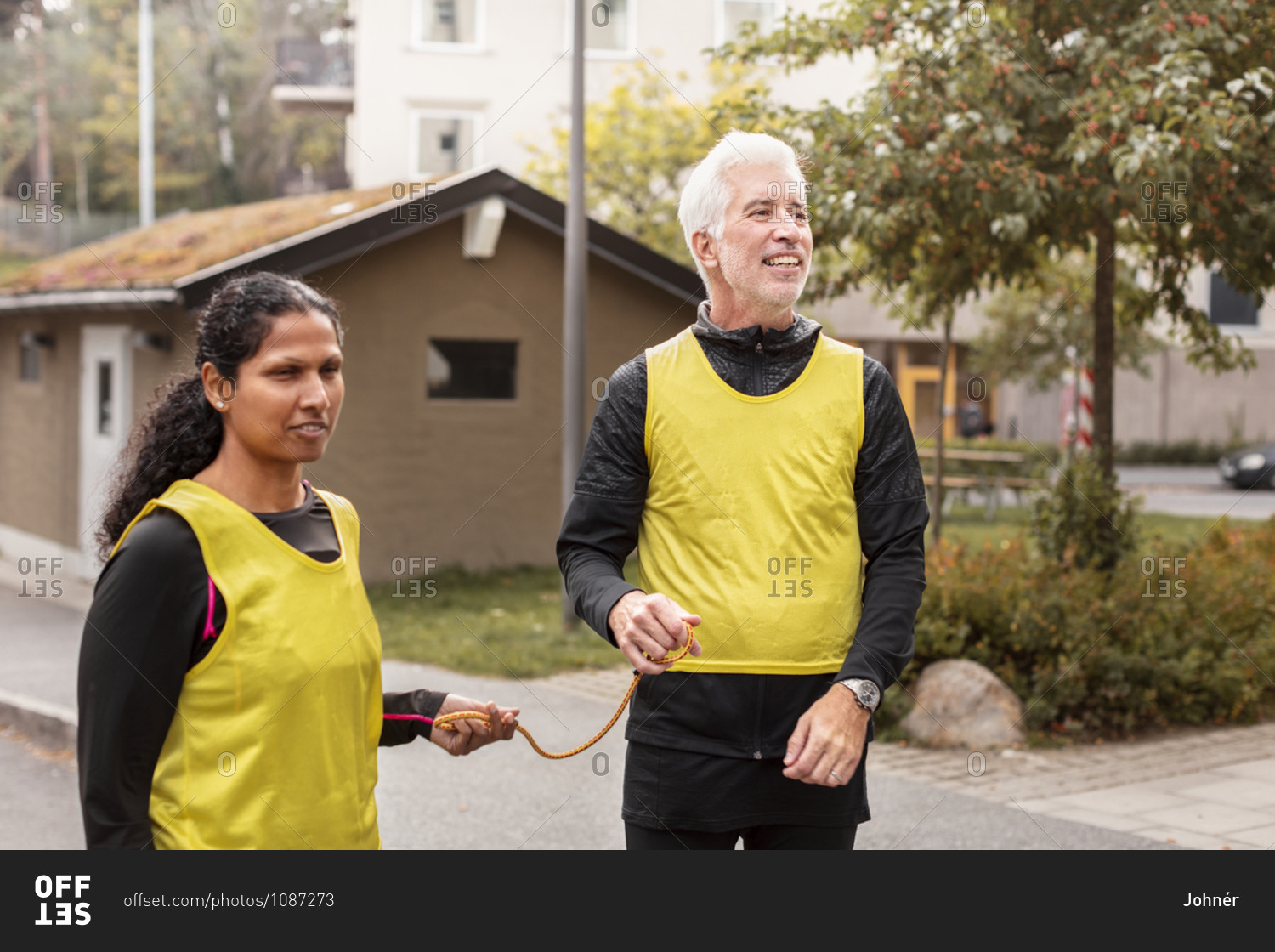 Visually Impaired Woman Preparing For Jogging With Guide Runner Stock Visually Impaired Woman Preparing For Jogging With Guide Runner Stock