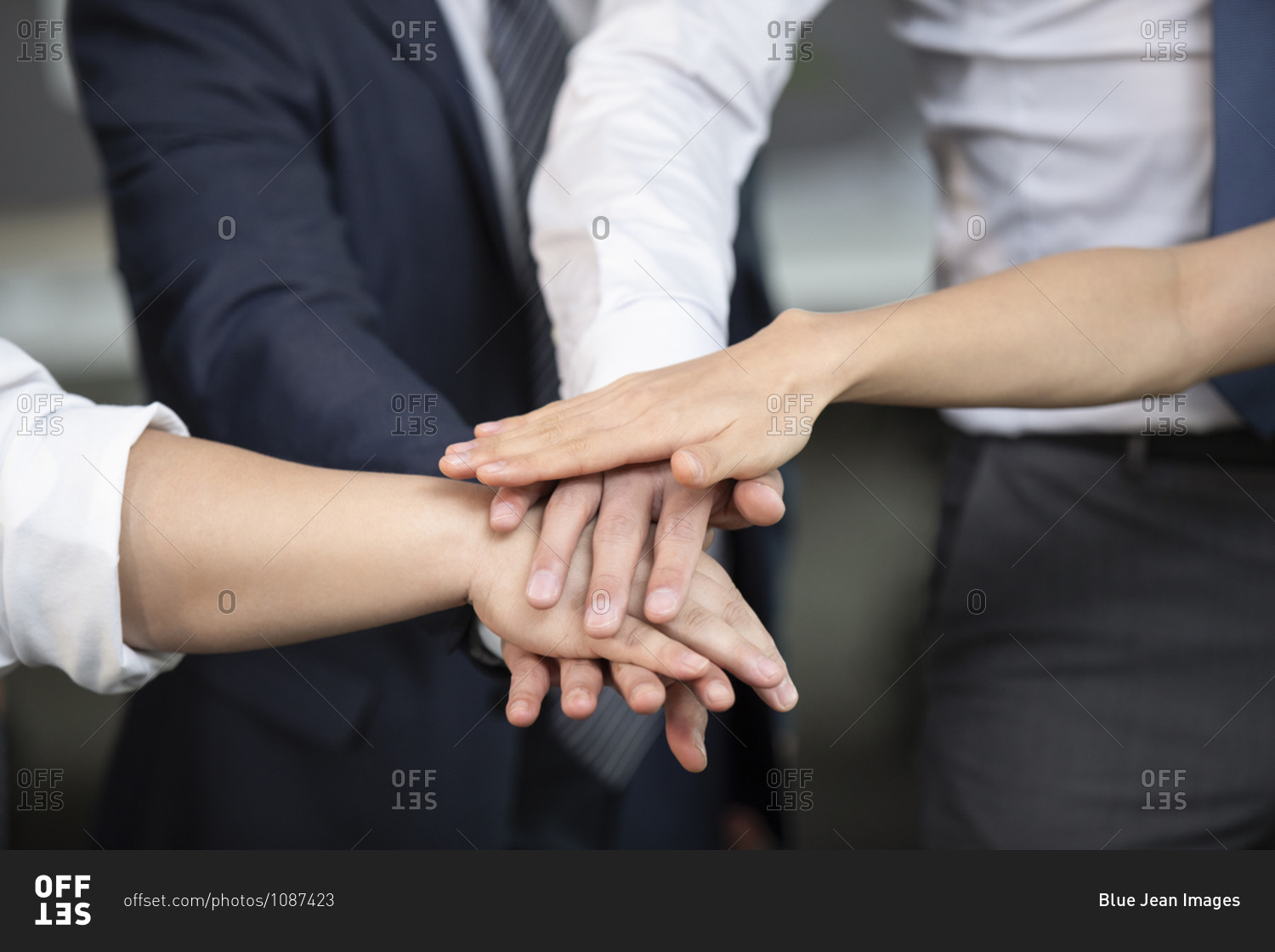 Business people stacking hands in office