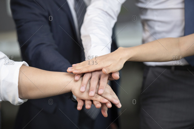 Business people stacking hands in office