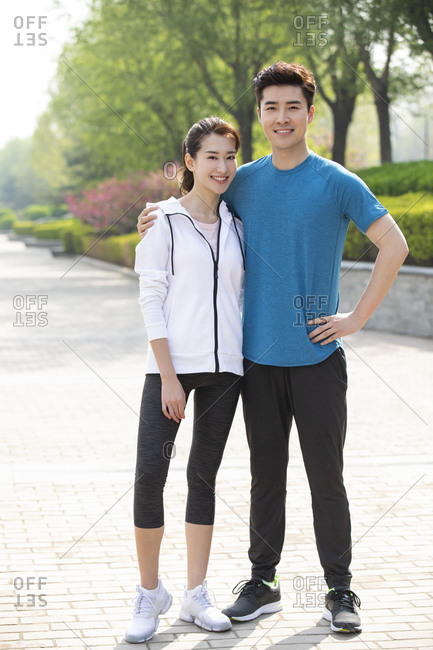 Happy young couple exercising in park