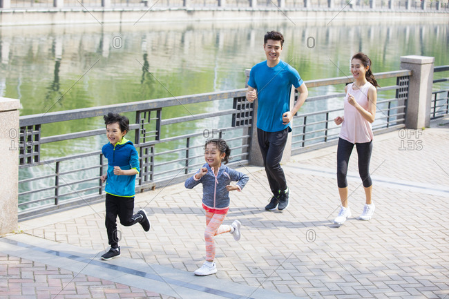 Happy young family running in park