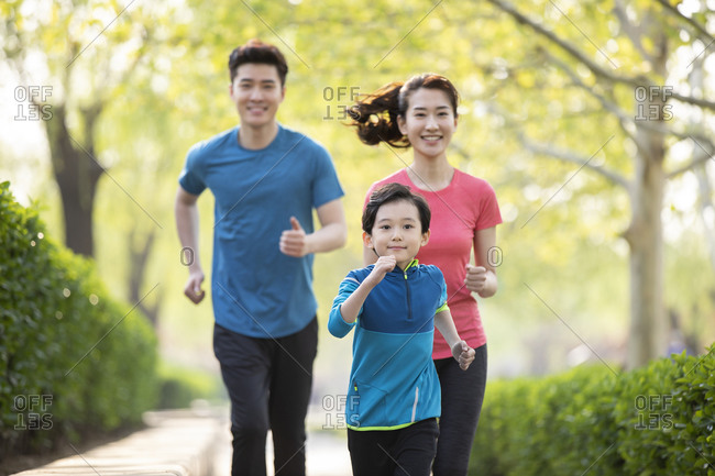 Happy young family running in park