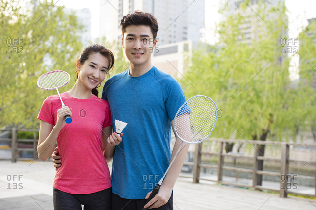 Happy young couple playing badminton in park