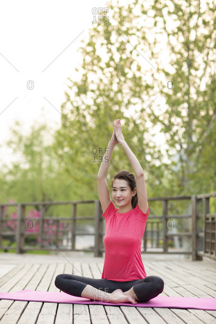 Happy young woman doing yoga in park