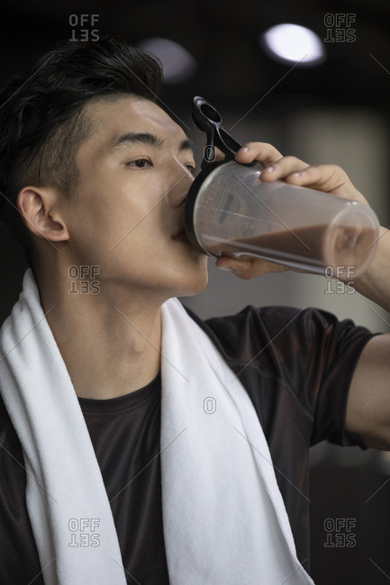 Young man taking a break from workout at gym