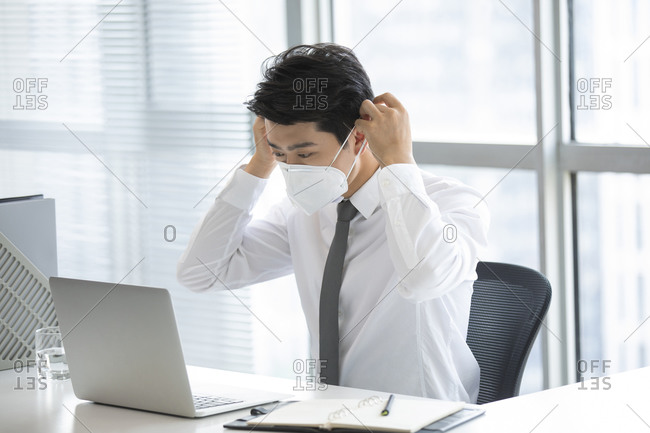 Young businessman wearing N95 mask in office