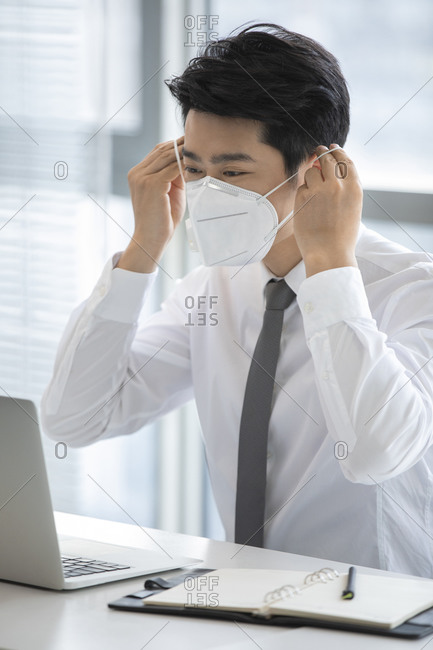 Young businessman wearing N95 mask in office