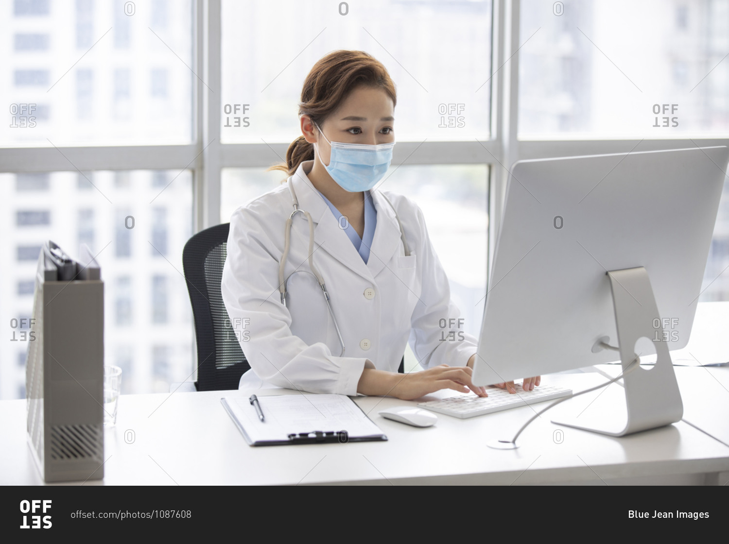 Young doctor using computer in doctor\'s office stock photo -\
OFFSET