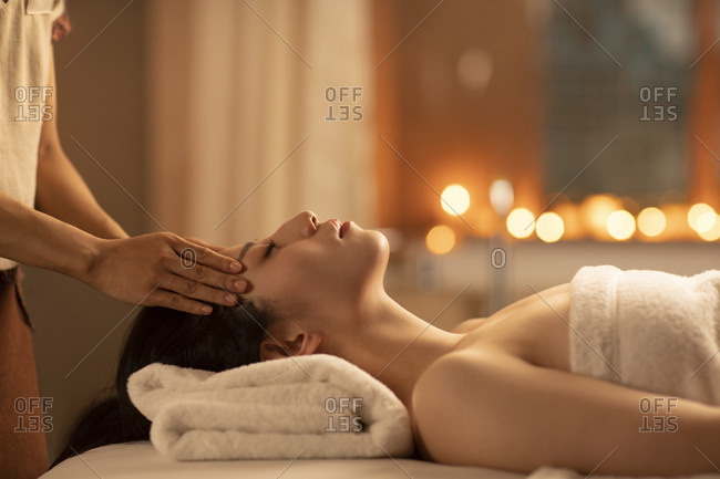 Young woman receiving facial massage at spa center