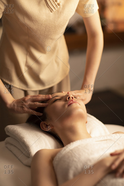 Young woman receiving facial massage at spa center