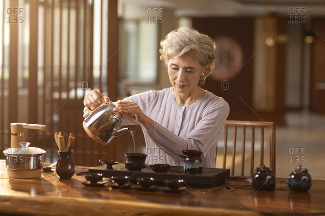 Senior woman performing tea ceremony