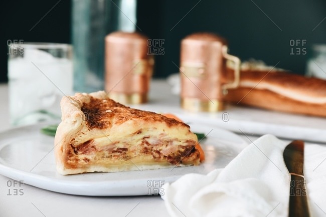 Quiche Lorraine dish served in a restaurant on table beside bread