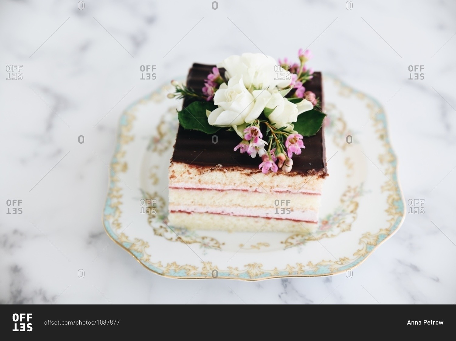 Layered cake topped with chocolate icing and flowers